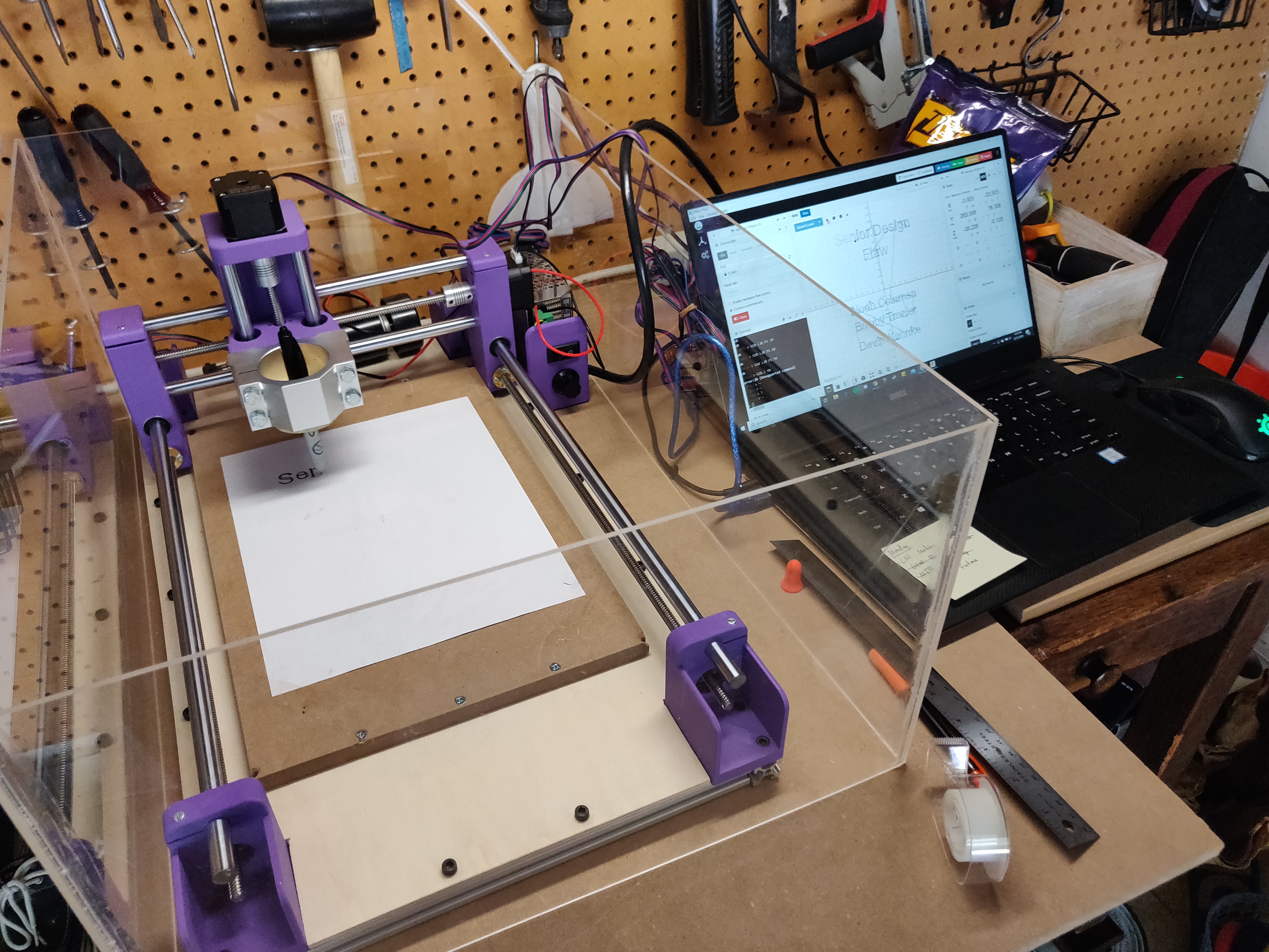 machine writes the letters s e n in progress of writting senior design flaw