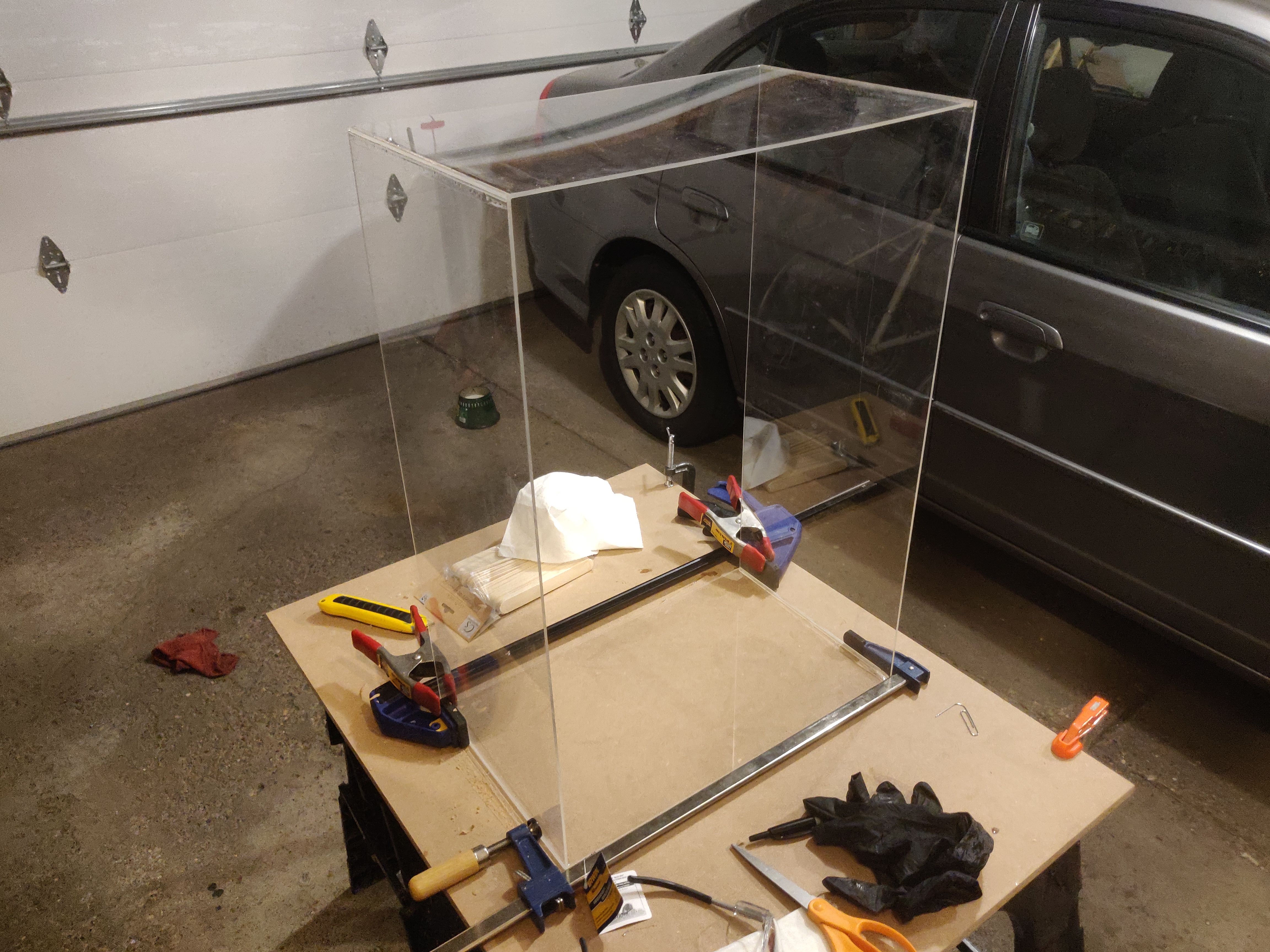 plexiglass box missing top and bottom standing on a side to let epoxy dry